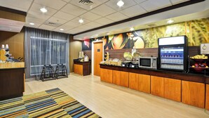 A hotel reception area with a counter, a microwave, a refrigerator, and a fruit display. - Fairfield Inn & Suites by Marriott Tampa Fairgrounds/Casino (Tampa)