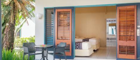 A room with a bed, a bathroom, and a small seating area with chairs and a table.