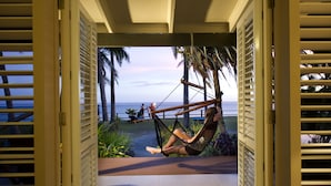 A view from a room with a balcony to the ocean, featuring a hammock chair and a pathway leading to the beach. - Fiji Hideaway Resort and Spa (Korolevu)
