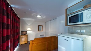 A compact kitchen with a microwave, a wooden cabinet, and a small refrigerator. - Noemys les Toits du Devoluy (Le Dévoluy)