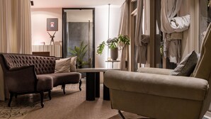 A modern living room with a brown sofa, beige armchair, and a small table. There is a potted plant and a framed picture on the wall. - B House Samui (Koh Samui)
