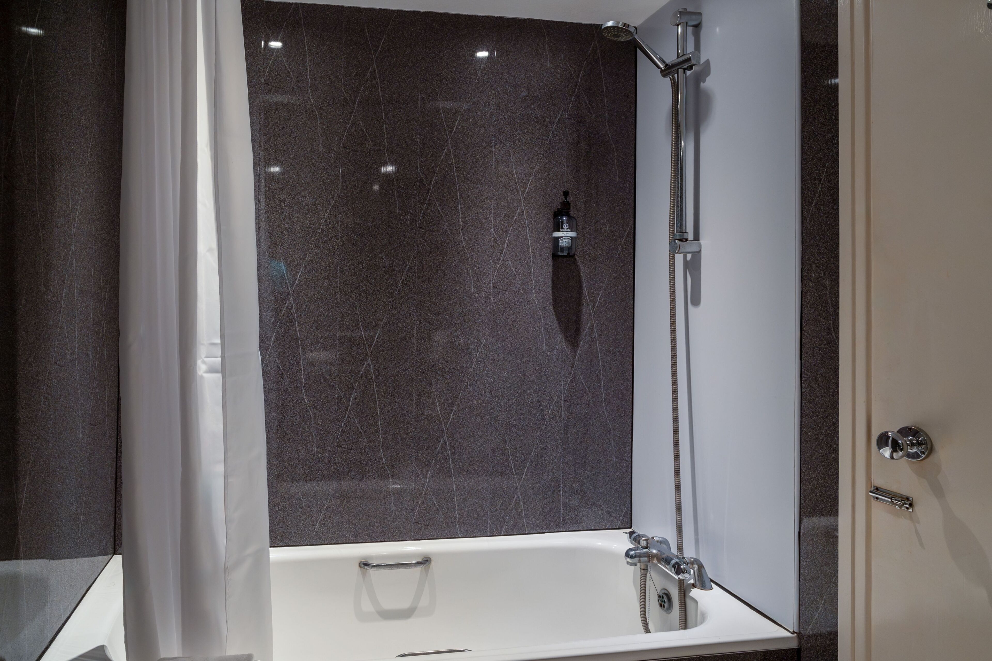 A modern bathroom with a shower, a bathtub, and a mirror.