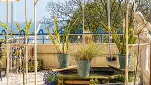 A garden area with potted plants, a fountain, and a view of the sea. - The Royal Hotel (Scarborough)