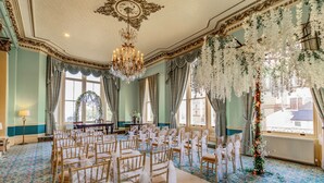A room with rows of chairs, a chandelier, and a floral arrangement. - The Royal Hotel (Scarborough)