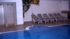 A swimming pool with lounge chairs and a door to the left. - Edelweiß (Goetzens)