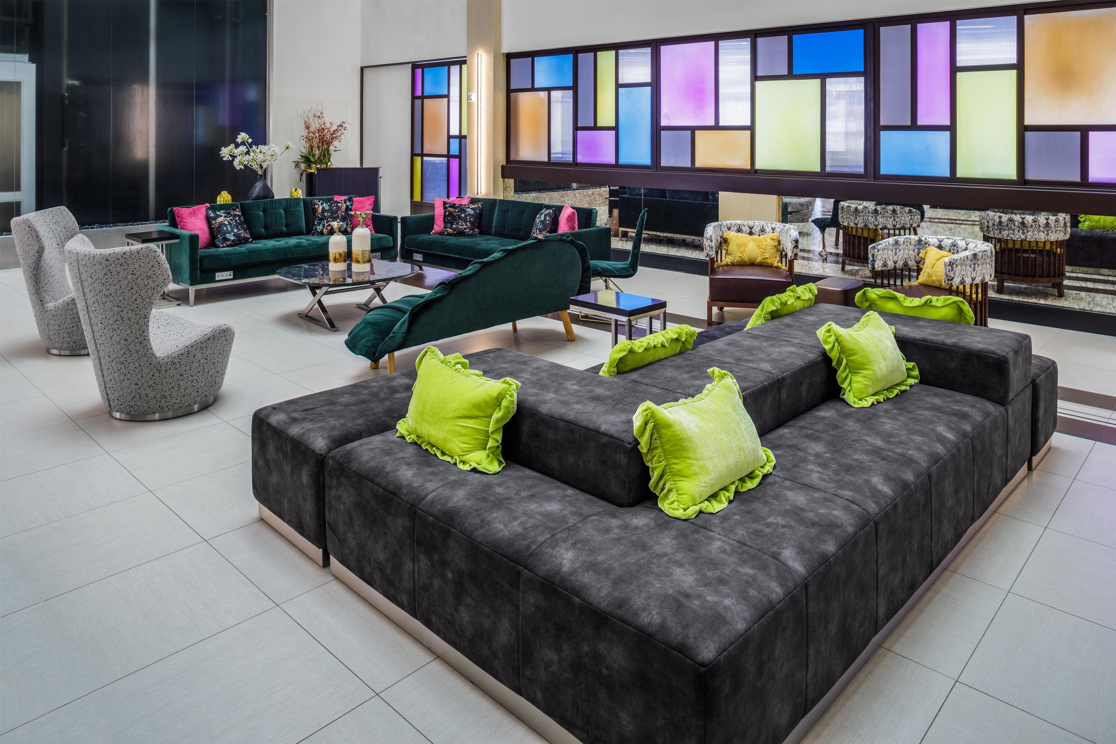 Un vestíbulo moderno con un sofá modular, sillones y una mesa de centro.