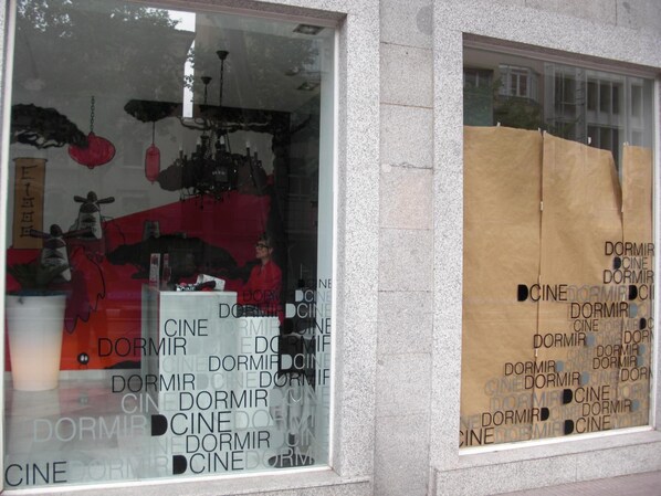 A building facade with a window displaying a pattern of the words "CINE DORMIR" repeated in various sizes.