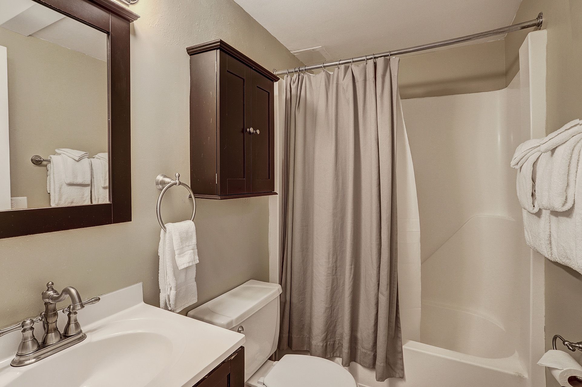 A bathroom with a sink, toilet, and shower.