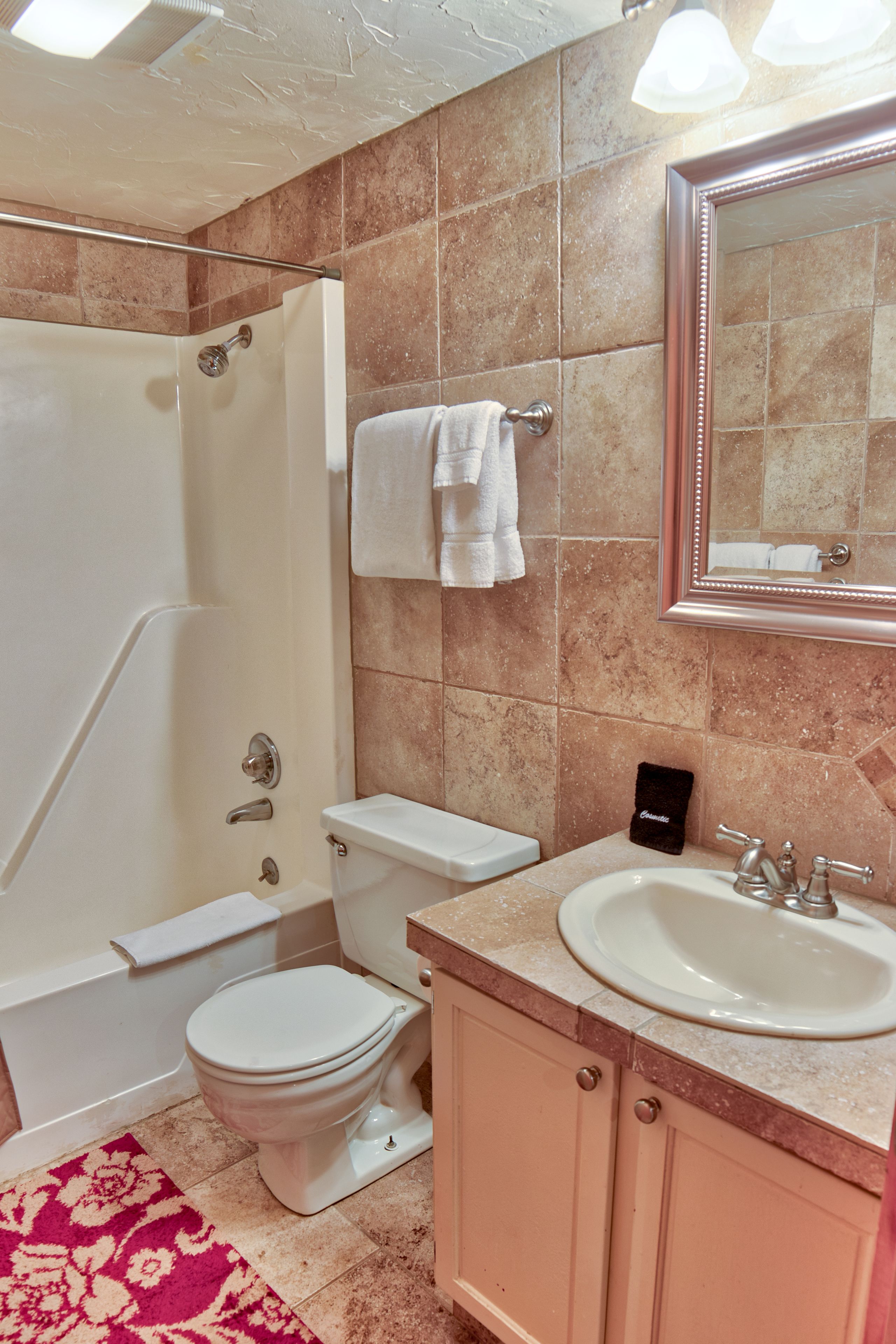 Ein Badezimmer mit Badewanne, Toilette, Waschbecken und Spiegel.