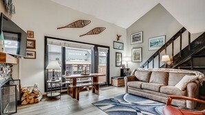 A cozy living room with a wooden floor, a sofa, a coffee table, and a staircase. - Der Steiermark (Breckenridge)