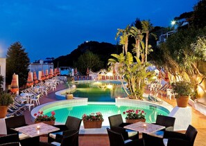 A poolside area with lounge chairs and umbrellas, surrounded by potted plants and a view of the pool. - Hotel Casa Di Meglio (Casamicciola Terme)
