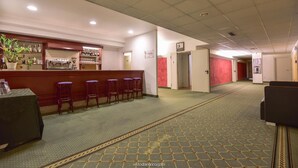 A hotel lobby with a bar area, seating, and a patterned carpet. - Standard Hotel Udine (Pradamano)
