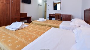 A hotel room with two beds, wooden wardrobe, a desk, a mirror, and a TV on the wall. - Standard Hotel Udine (Pradamano)
