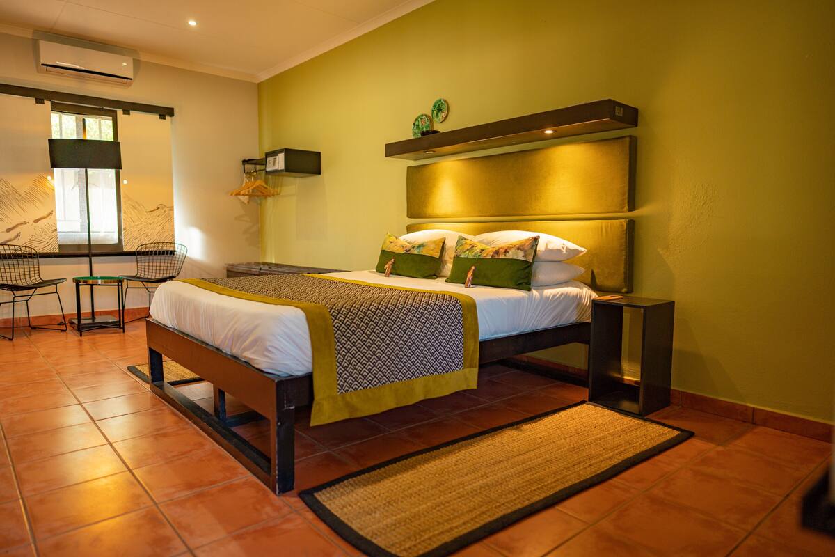 A bedroom with a bed, bedside tables, a chair, and a window.