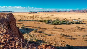 Set against a vast, arid landscape, this property offers breathtaking views of a prominent red rock formation.