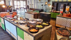 A buffet with various food items and a seating area with chairs and tables. - Namib Desert Lodge (Sesriem)