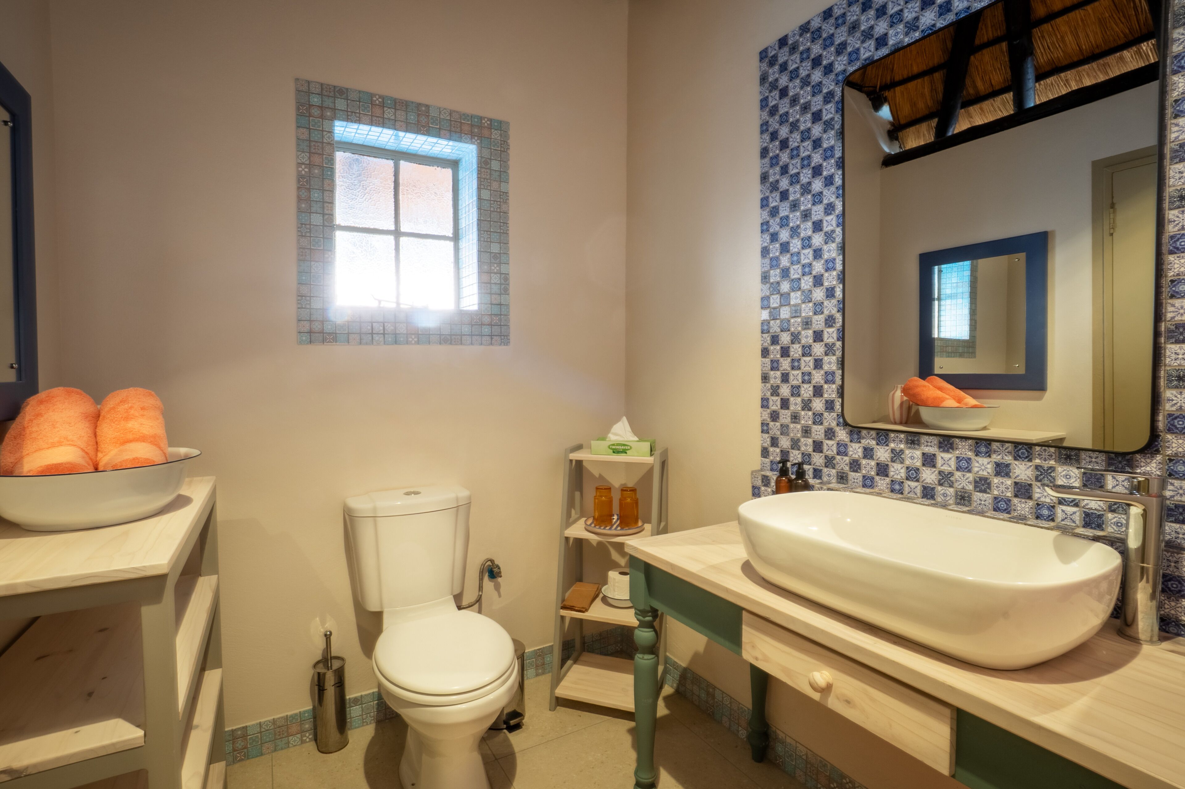 Ein Badezimmer mit Toilette, Waschbecken und einem kleinen Fenster.