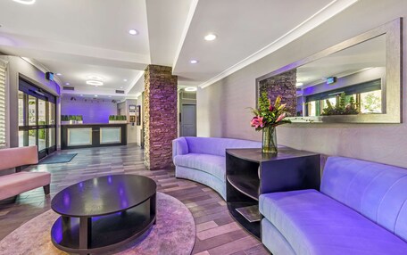 A modern lobby with a curved sofa, a round coffee table, and a reception desk.