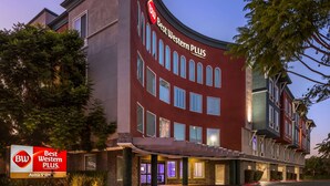 Un hotel con fachada curva, numerosas ventanas y un llamativo letrero 'Best Western Plus'.