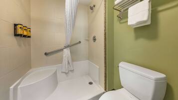 A bathroom with a shower, toilet, and towel rack.