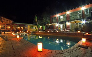 Una piscina al aire libre, sombrillas, sillones reclinables de piscina