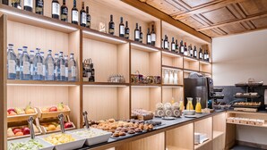 A breakfast buffet with various food items and beverages, including fruits, pastries, and wine bottles. - Hotel Chalet Bassibe (Naut Aran)