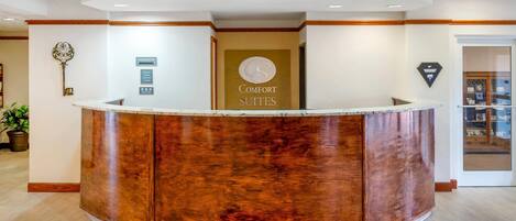 A reception desk with a sign for 'Comfort Suites'.