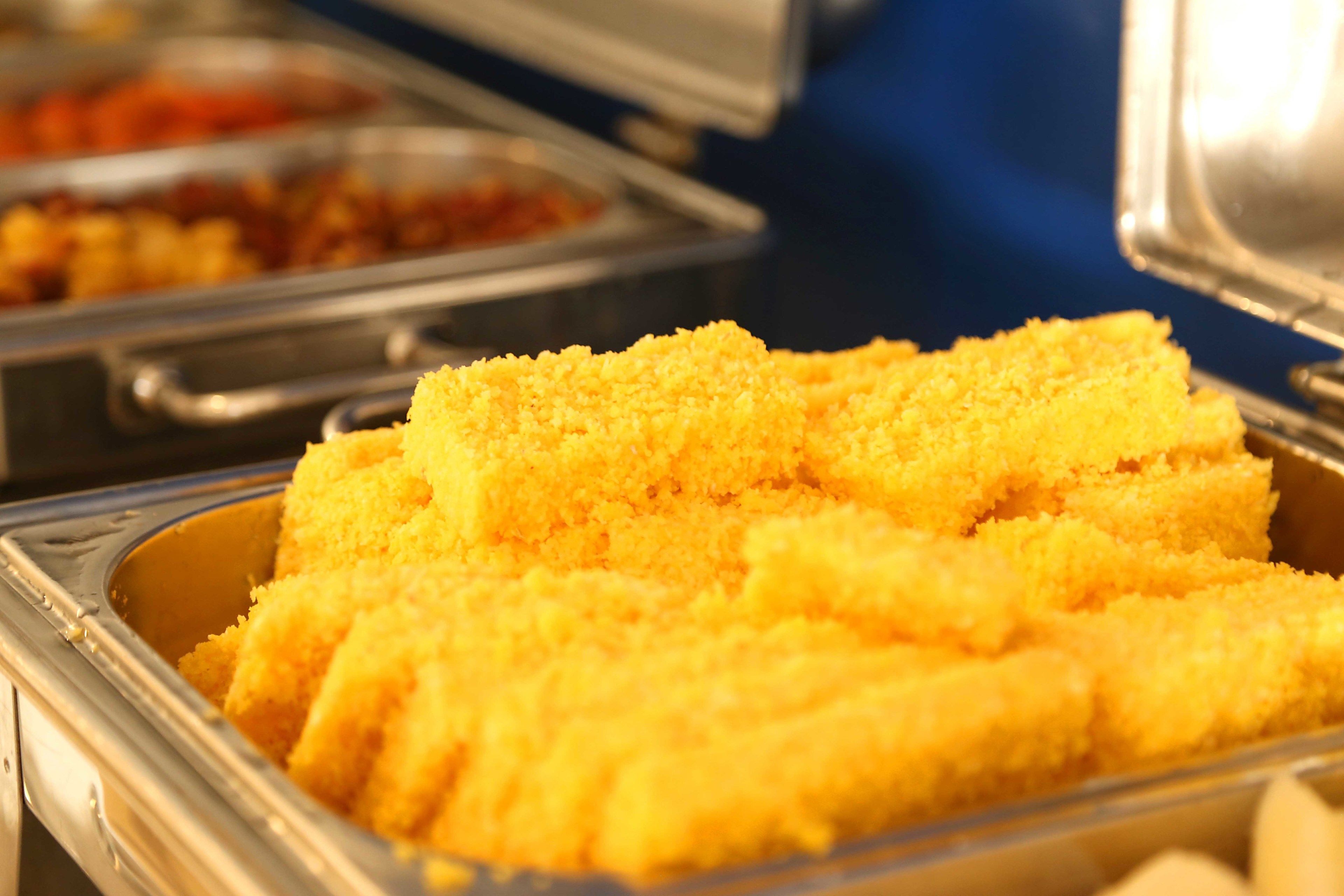 A buffet with various food items, including a section with yellow-colored food.