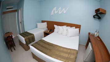 Une chambre d’hôtel avec deux lits, un bureau, une chaise, une armoire et un petit réfrigérateur.