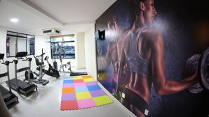 A gym with treadmills, stationary bikes, and a colorful mat. - Real Praia Hotel (Aracaju)