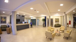 A spacious lobby with a reception desk, seating area, and a large plant. - Real Praia Hotel (Aracaju)