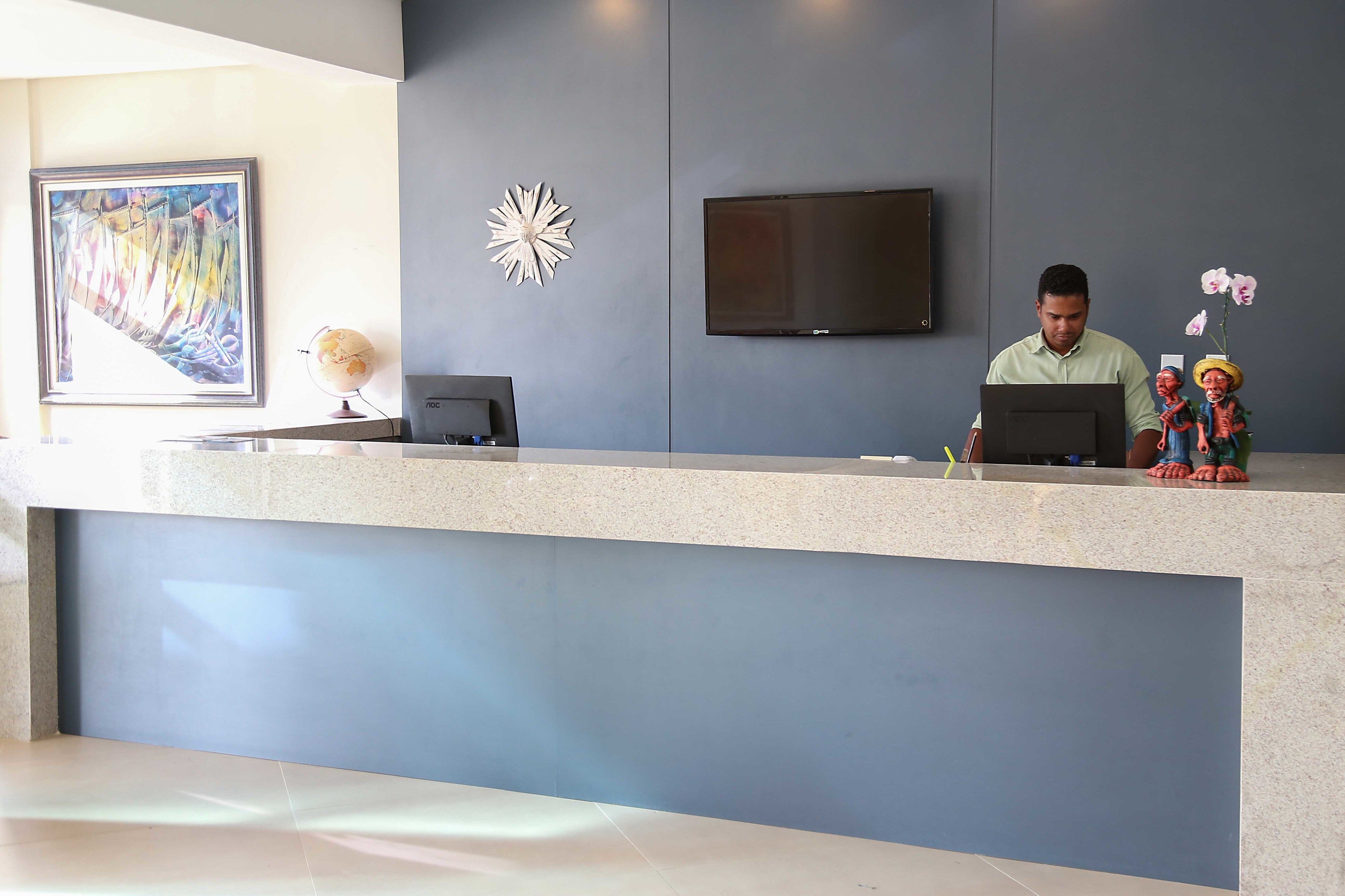 A reception desk with a flat-screen TV, a globe, and decorative items.