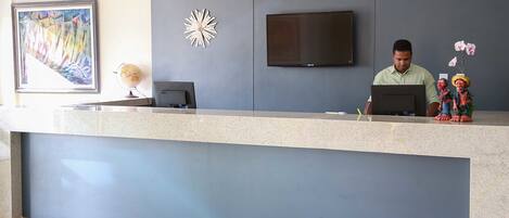 A reception desk with a flat-screen TV, a globe, and decorative items.