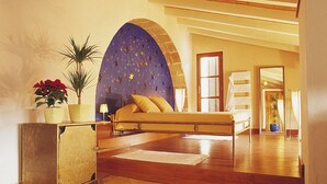 Une chambre à coucher avec un lit, une table de chevet, une plante en pot et un mur décoratif.
