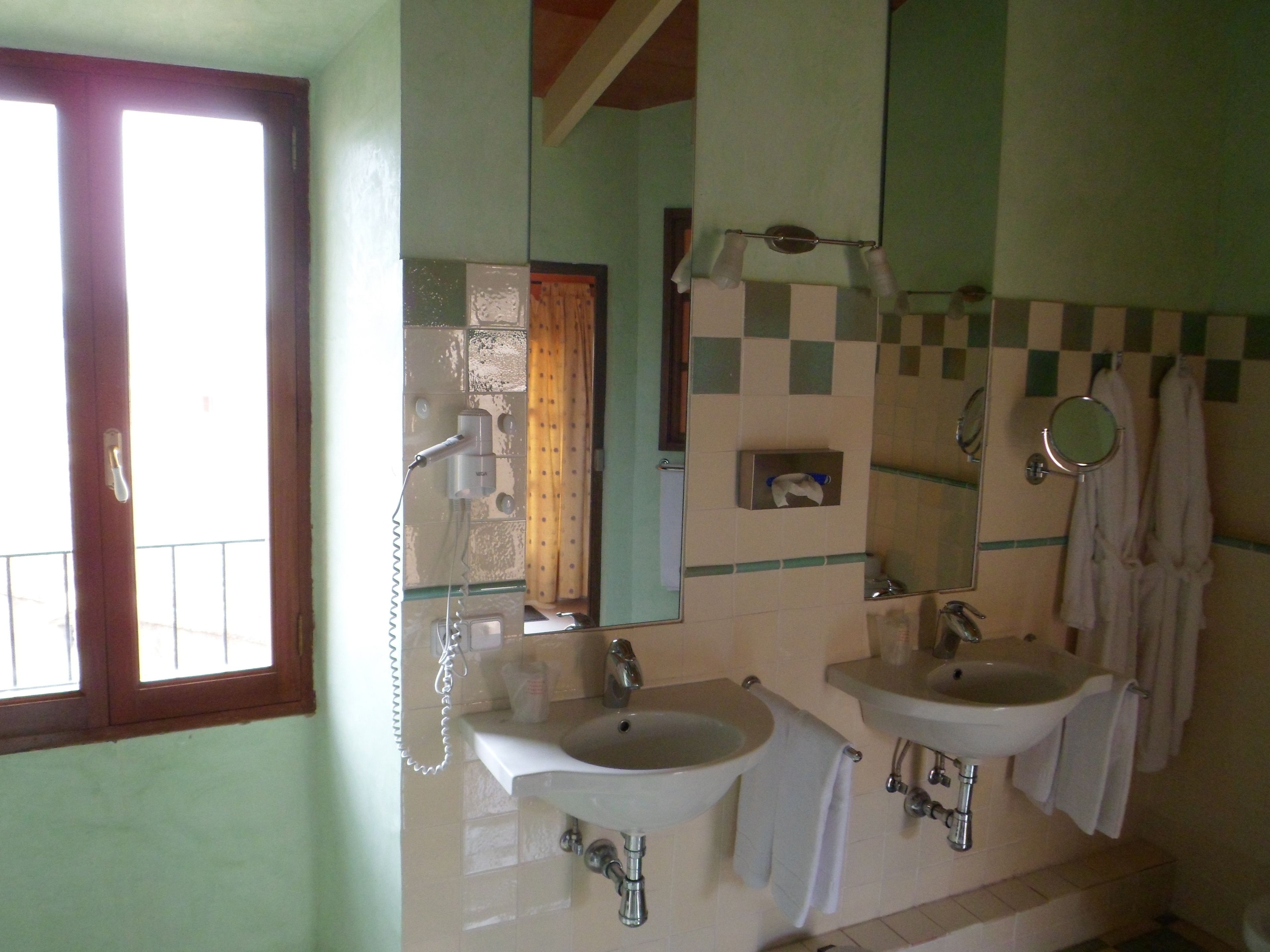 A bathroom with two sinks, a mirror, and a towel rack.