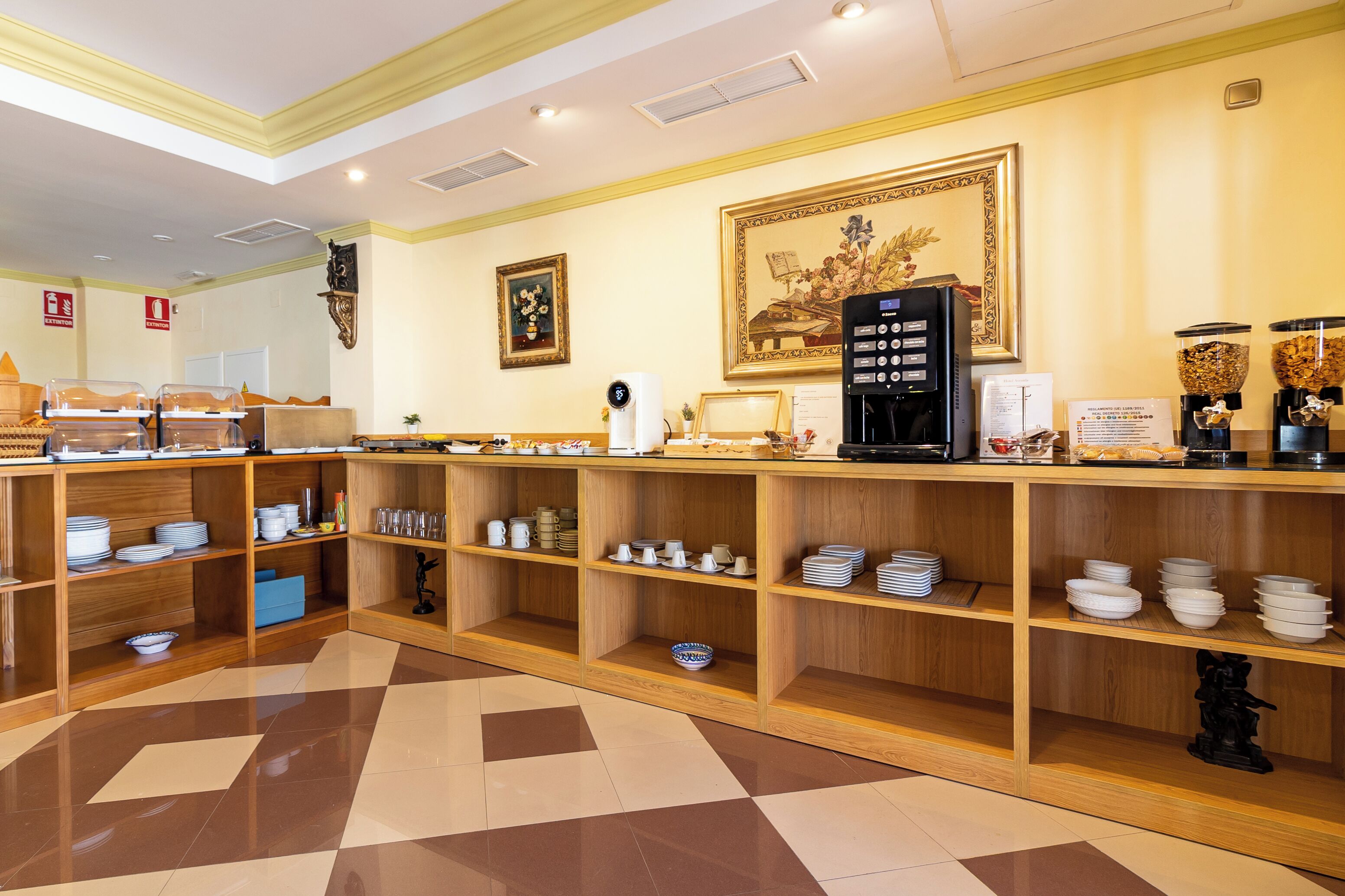 A buffet area with wooden shelves stocked with plates, bowls, and glasses.