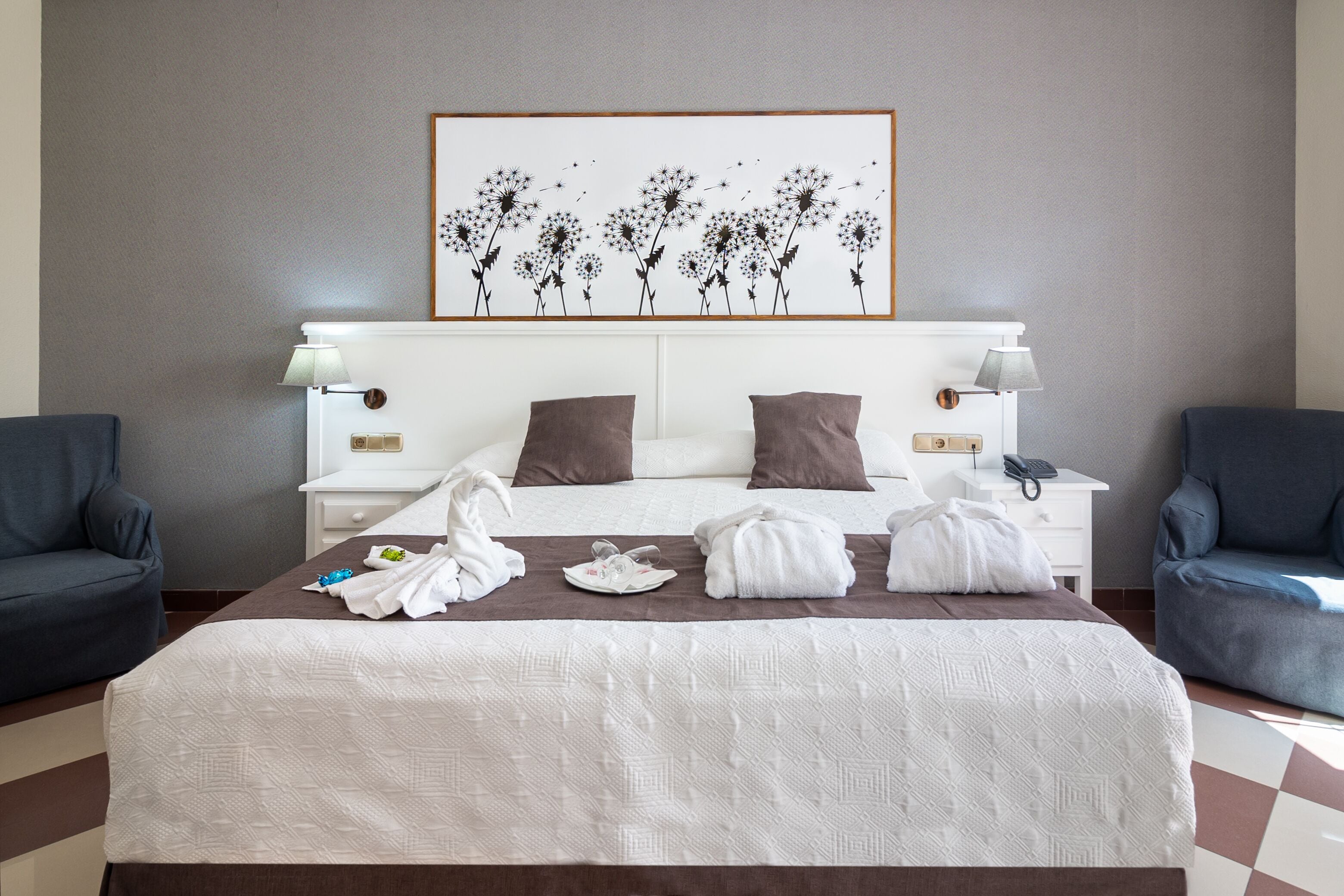 Una camera d'albergo curata con un letto grande, due comodini e un quadro appeso al muro.