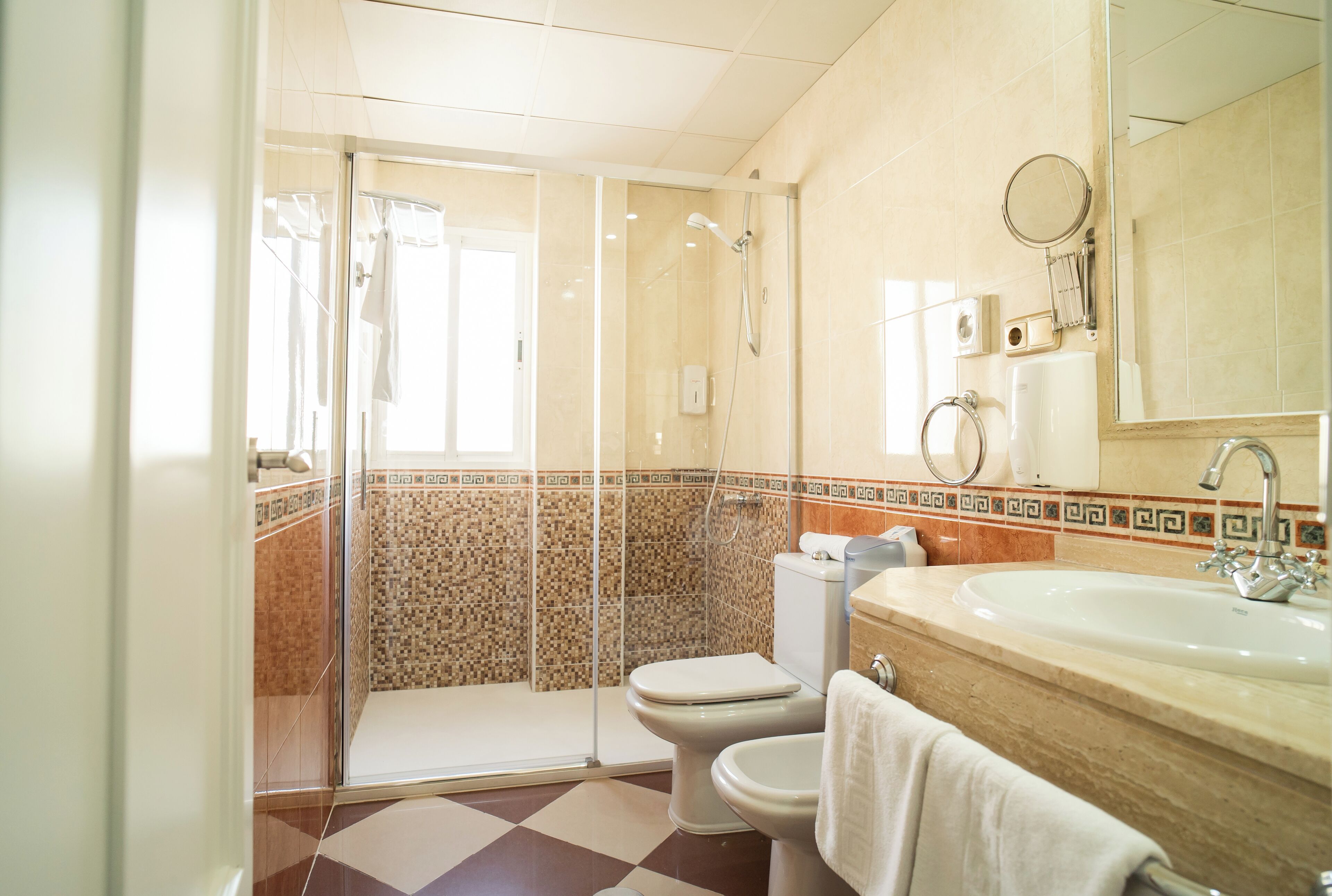 Un bagno con doccia vetrata, un water, un lavandino e uno specchio.