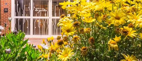 A building with a glass door entrance and a sign that reads "Welcome to the garden."