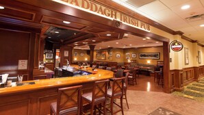 A bar area with a counter, stools, and framed pictures on the walls. - Hilton Garden Inn Bangor (Bangor)