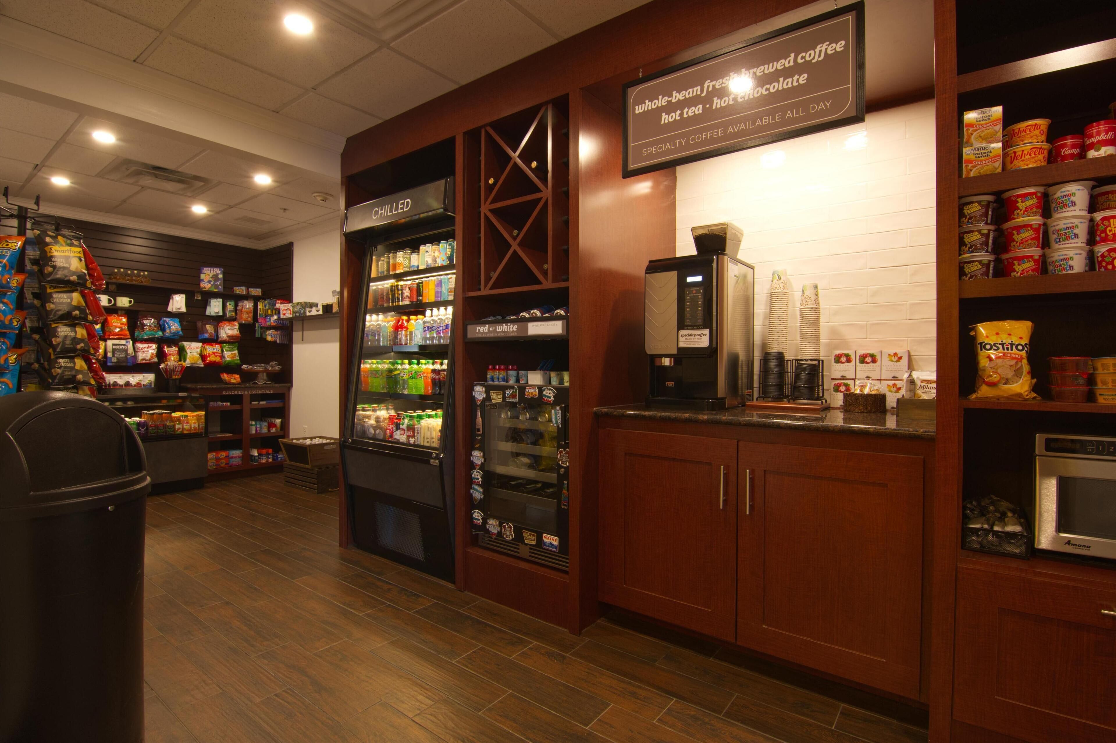 Ein Café-Interieur mit einer Kühlvitrine, einer Kaffeemaschine sowie verschiedenen Snacks und Getränken.