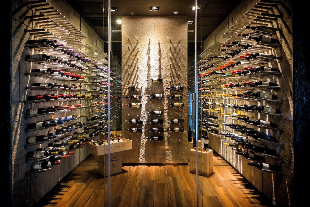 A wine cellar with rows of wine bottles on shelves.