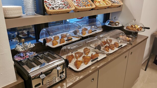 Un buffet de petit-déjeuner proposant un assortiment de viennoiseries, de pains et un grille-pain.