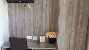 Un espace de travail compact comprenant un bureau, une chaise et un téléviseur intégré.