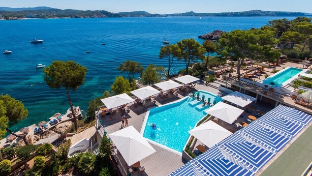 Un resort con piscina, zona de playa y vistas al mar.