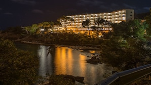 Un hôtel à plusieurs étages doté de balcons, offrant une vue sur le front de mer et comprenant un espace piscine.