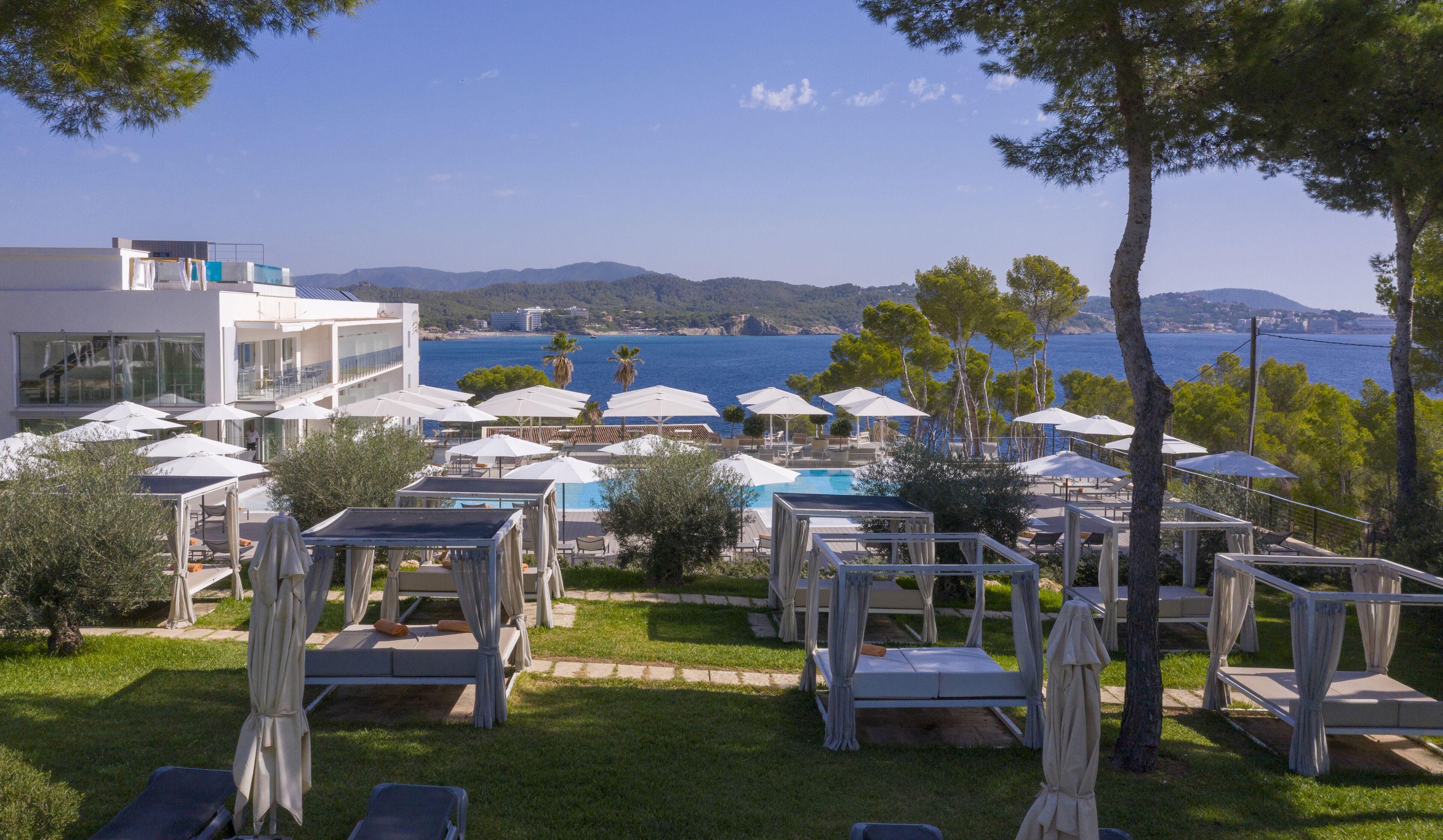 Ein Resort mit Außenbereich, einem Pool und Blick auf Meer und Berge.