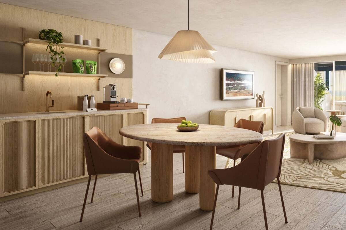 A modern kitchen with wooden cabinetry, a round dining table, and a pendant light.