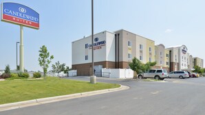A hotel with a prominent sign, a parking lot, and a building with multiple windows. - Candlewood Suites Gillette by IHG (Gillette)