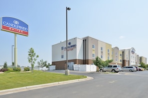 A hotel with a prominent sign, a parking lot, and a building with multiple windows. - Candlewood Suites Gillette by IHG (Gillette)